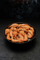 Boiled big sea prawns or shrimps placed on black ceramic plate