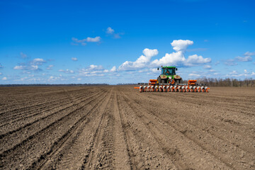 Fototapeta premium tractor with seeder in the field in early spring