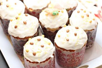 Rows of freshly baked decorated Easter cakes on white background