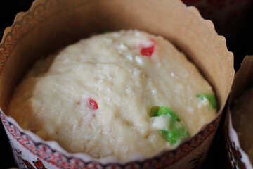 Raw dough with candied fruits for Easter cakes in paper tins, ready for baking