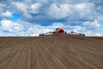 tractor with seeder in the field in early spring