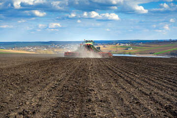 tractor with seeder in the field in early spring