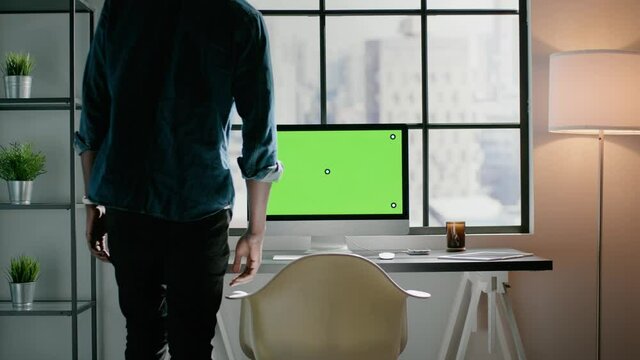 Freelancer works on project on computer with green screen