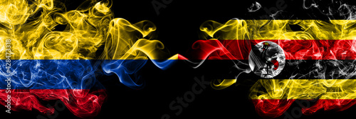 Colombia, Colombian vs Uganda smoky mystic flags placed side by side. Thick colored silky abstract smokes flags.