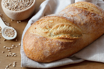 A loaf of bread and wheat grains
