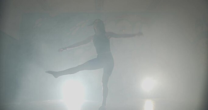 Silhouette dance in foggy room