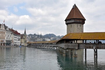 Lucerne, Switzerland - 04 17 2021: Chapel Bridge over river Reuss with Water Tower built in water in Lucerne in Switzerland. A historical building and a landmark of the city attracting tourists. 