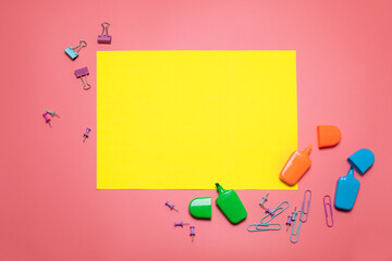 Stationery items on the pink background with free space for text. Creative, colorful background with scool or office supplies. Flatlay with copy space, top view. Markers, paper clips