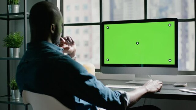 Bald black office worker designs new project on computer