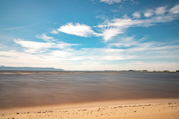 Sand, clouds and lake with blue sky