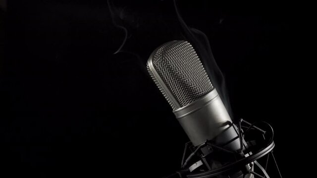 Smoking microphone. Professional audio recording equipment on an anti vibration stand, side lit