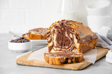 Loaf of marble pound cake on a board on a gray concrete background. Copy space.