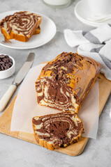 Loaf of marble pound cake on a board on a gray concrete background. Copy space.