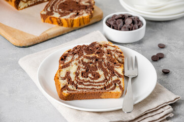 Loaf of marble pound cake on a board on a gray concrete background. Copy space.