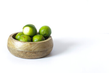 Fresh organic juicy limes in wooden bowl.