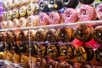 Colorful sweet background. Delicious glazed donuts on a shop window