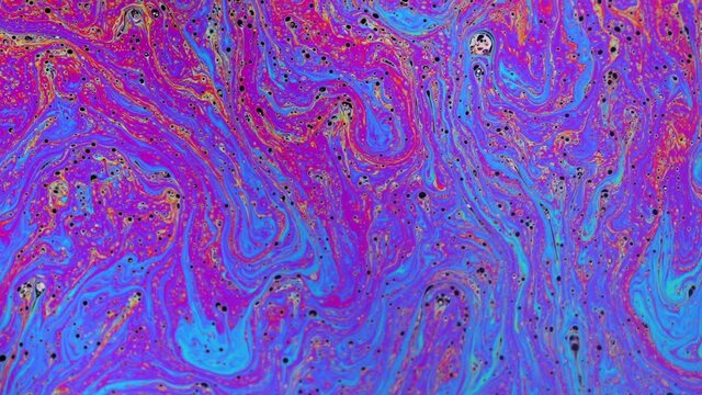 Psychedelic abstract colours and patterns reflecting on a soap bubble.