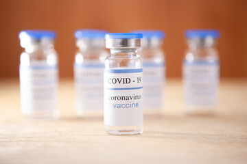 Coronavirus Vaccination - ampoules on brown background, pandemic