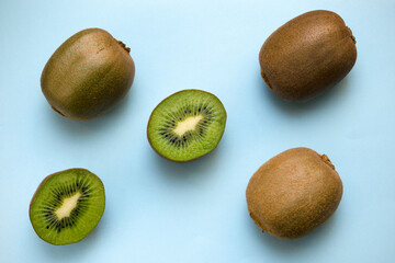 whole and halved kiwi on a colored blue background