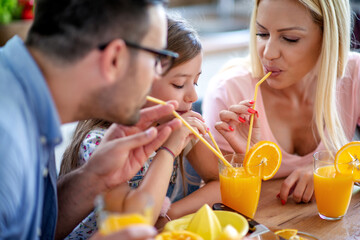 Happy family drink orange juice