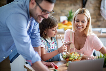 Family using laptop during cooking in kitchen