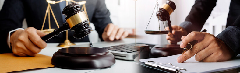 Business and lawyers discussing contract papers with brass scale on desk in office. Law, legal services, advice, justice and law concept picture with film grain effect