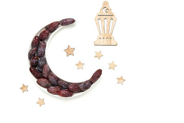 Ramadan kareem with medjool dates arranged in shape of crescent moon.  Iftar food concept. Top view, copy space © Veliavik