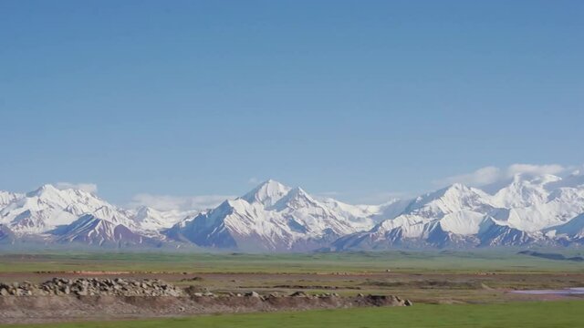 Snowy Pamir Mountains viewed from car window, Kyrgzstan.