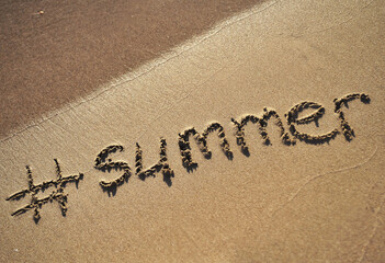  The word summer written on sand texture.