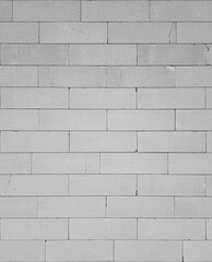 A fragment of a white wall made of blocks, rough masonry, texture or wallpaper