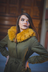 Shallow focus shot of a confident Caucasian female in a puffer posing for the camera