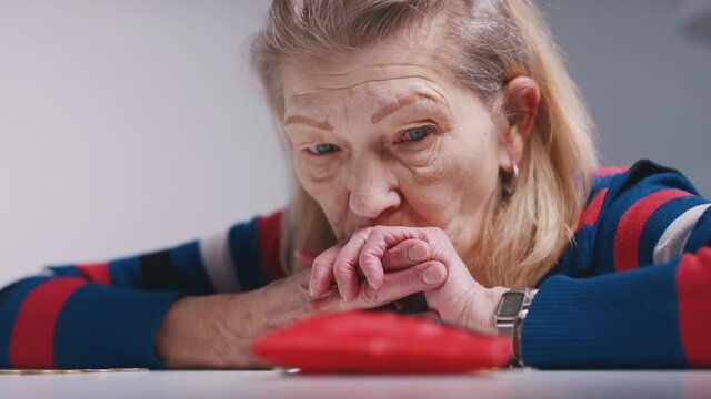 sad poor elderly woman counting coins and looking at an empty wallet. High quality 4k footage