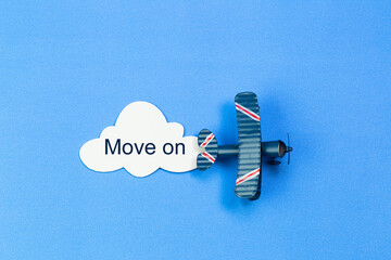 writing Move on red toy airplane with cloud on blue background