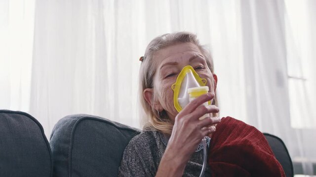 Older Woman Using A Respiratory Mask Inhaling Medicine To Clear Out Her Throat And Sinuses. High Quality 4k Footage