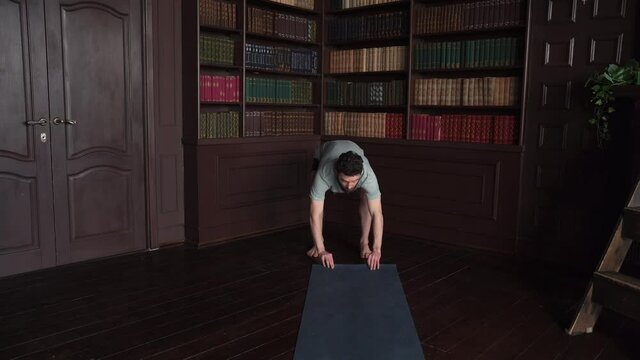 4k Shot Of A Man Rolling Out Yoga Mat At Home