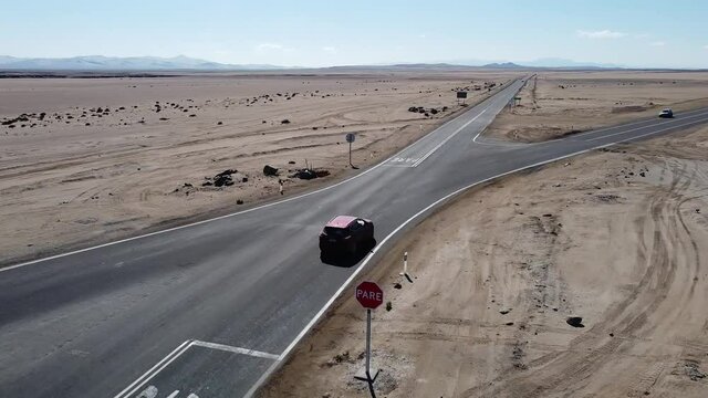 SUV Car on Crossroad in the Desert of Atacama, Fork Junction where the Road is Splitted in Two Different Ways, Atacama Desert, Chile, South America. Drone View.