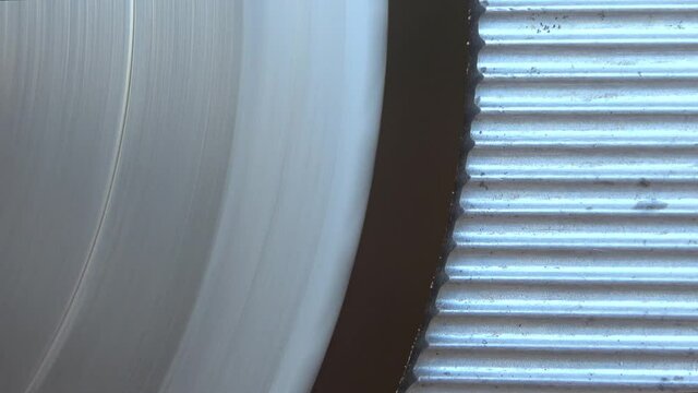 Close up view on a sharp rotating steel cutting blade of a cutting machine