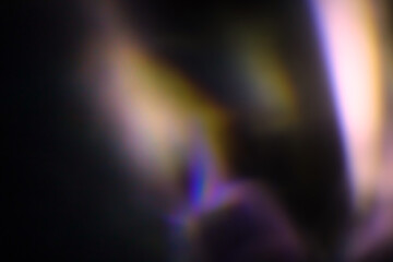 Blur colorful warm rainbow light leaks on black background with dust texture. Defocused abstract damaged scratched retro film analog effect for using over photos as overlay or screen filter
