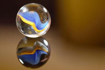 Yellow and blue marble with a mirror reflection - stock photo