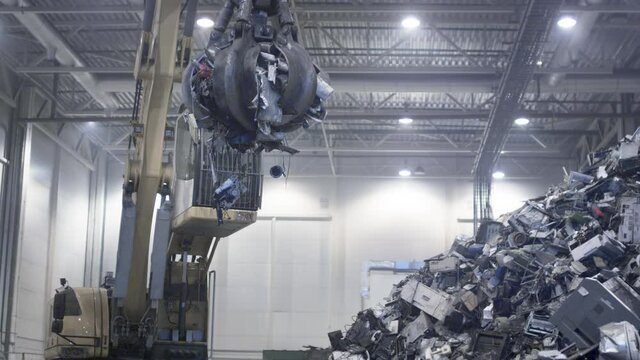 Garbage mountains. Excavator claw grabs trash on a heap in a landfill, displacing fragments of waste. Eco-friendly waste recycling. Recycling of plastic at a waste recycling plant. Waste Dump Machine
