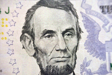 Abraham Lincoln portrait on the banknote of 5 dollars, five American dollars background, selective...