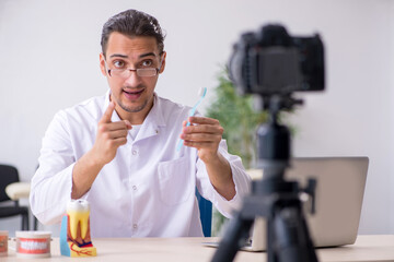 Young male doctor dentist recording video for his blog