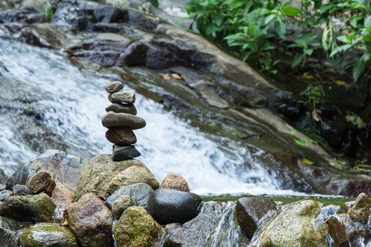 Arte de empilhar pedras para medita&ccedil;&atilde;o nas margens de uma bela cachoeira 
