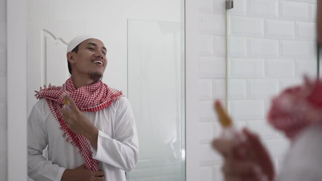 portrait of muslim asian man looking at mirror and get dressed before going to the mosque