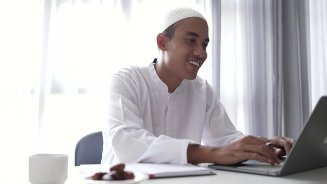 asian muslim businessman working using laptop while sitting on the desk