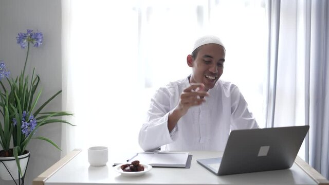 happy asian muslim man meeting using laptop for video call conference