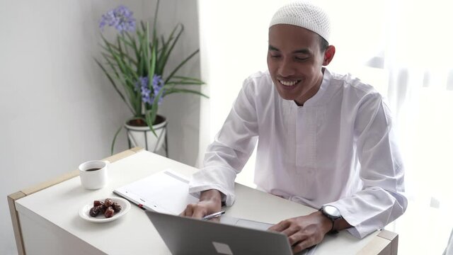 asian muslim businessman working using laptop while sitting on the desk