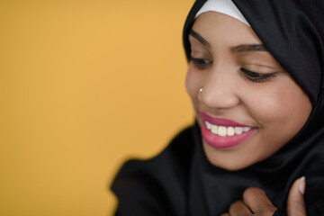 african muslim woman with a beautiful smile takes a selfie with a cell phone