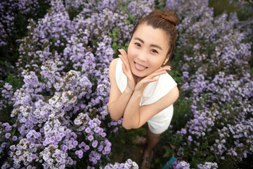 young attractive beautiful happy asian woman with white dress and soft touch purple aster margaret...