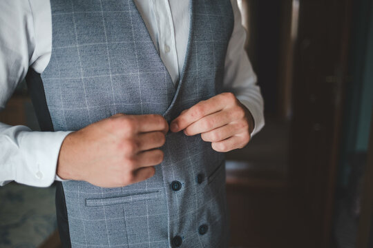 Closeup of a man buttoning his ves